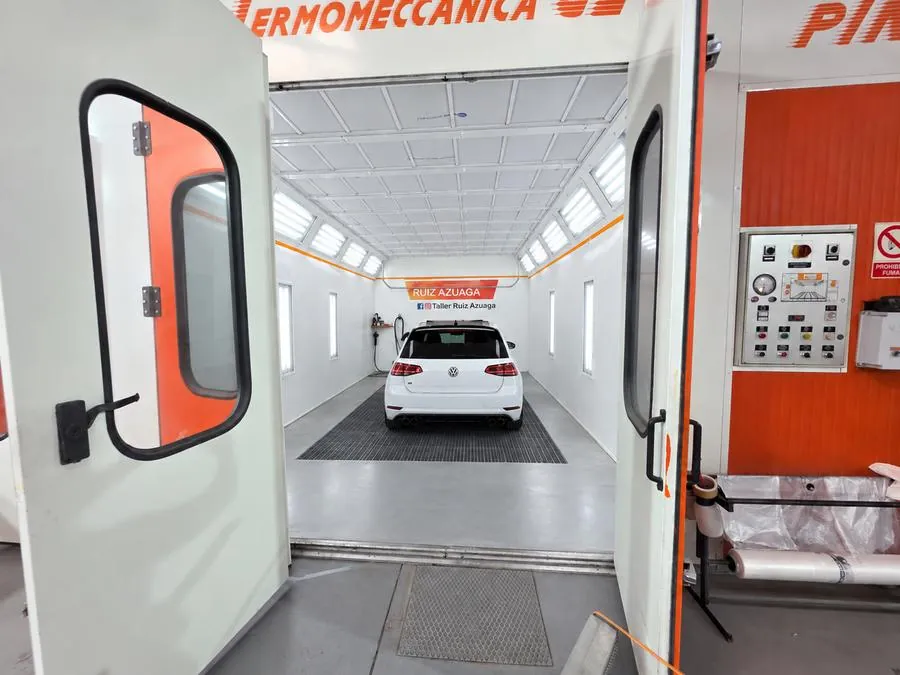 Volkswagen Golf recién pintado dentro de la cabina de pintura del taller Ruiz Azuaga