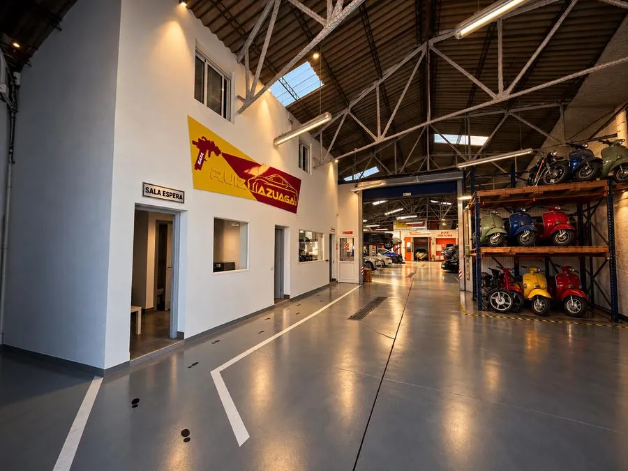 Interior del taller Ruiz Azuaga con el rótulo, la sala de espera y la colección de Vespas